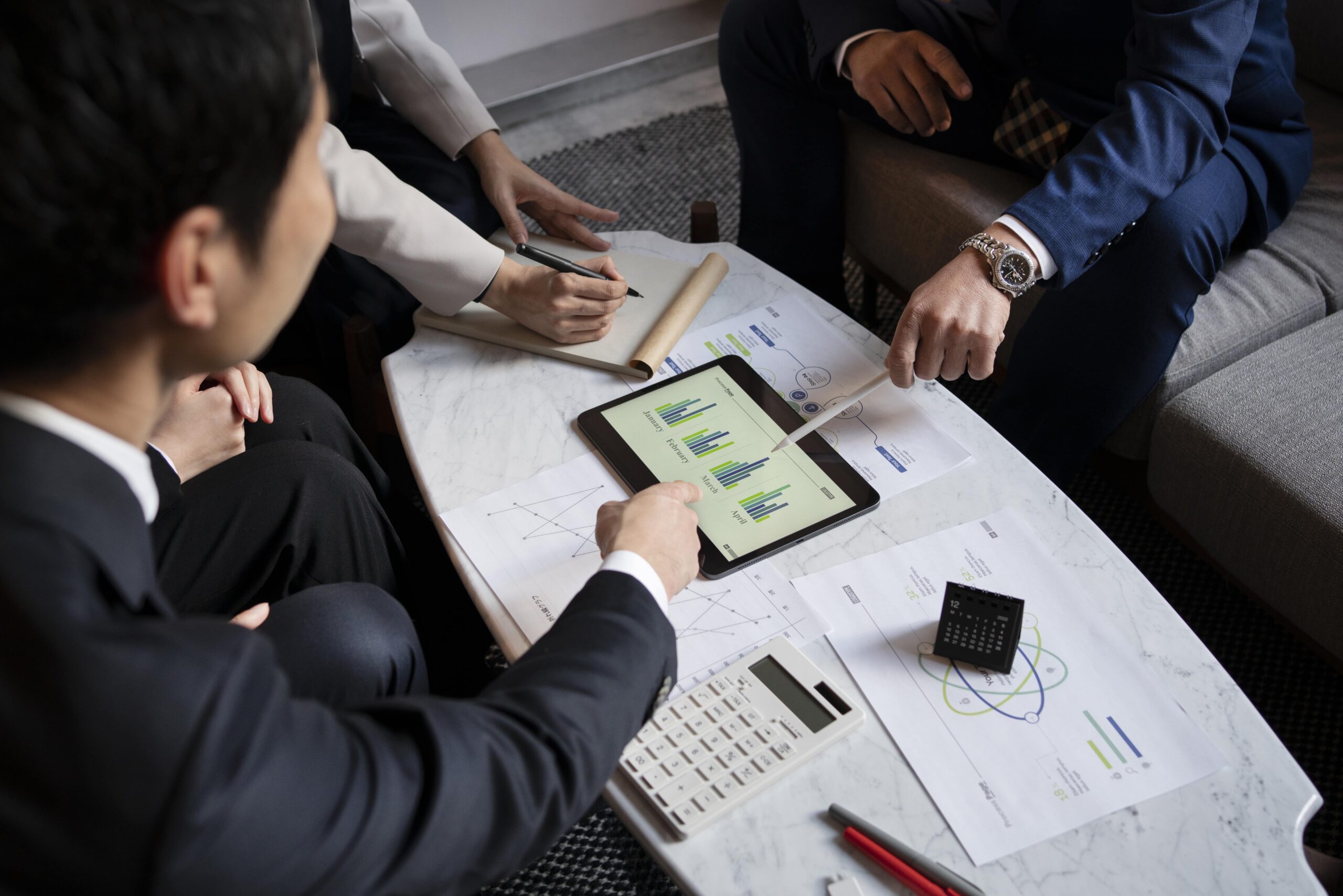 Business professionals reviewing financial charts and capital strategies for sustainable growth and compliance